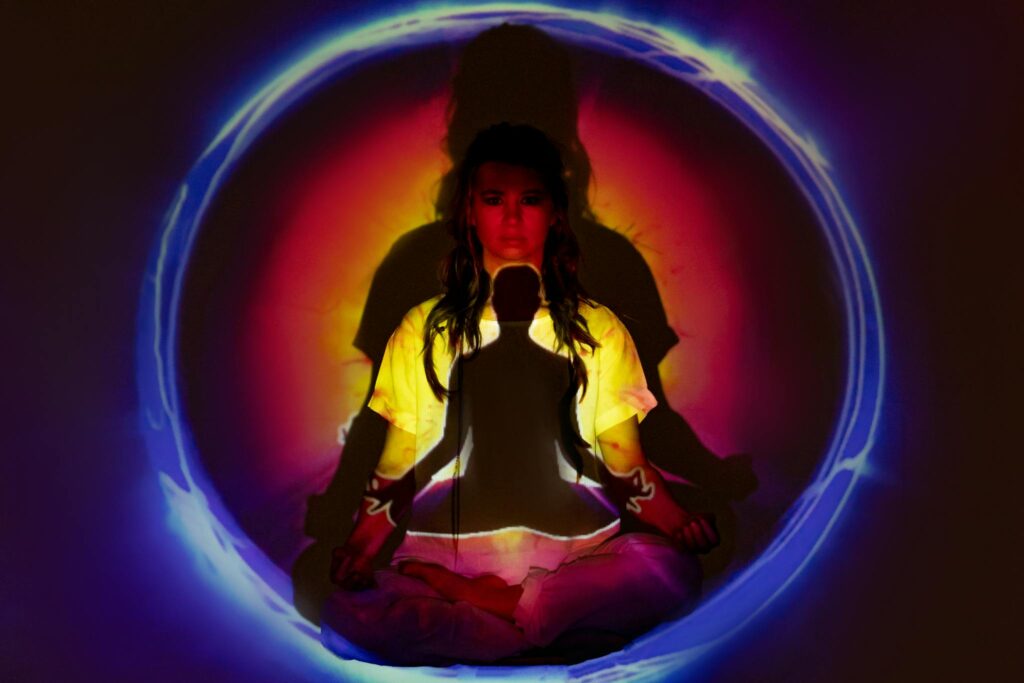 Woman meditating with vibrant aura and energy field.